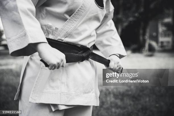 female fighter tightening karate belt - black belt martial arts stock pictures, royalty-free photos & images