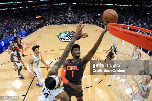 Jonathan Isaac of the Orlando Magic shoots over Brandon Ingram of the New Orleans Pelicans during a NBA game at Smoothie King Center on December 15,...