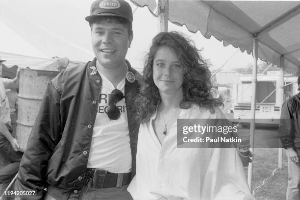 American actress Debra Winger poses with an unidentified man, backstage at the inaugural Farm Aid benefit concert at Veteran's Stadium, Champaign,...