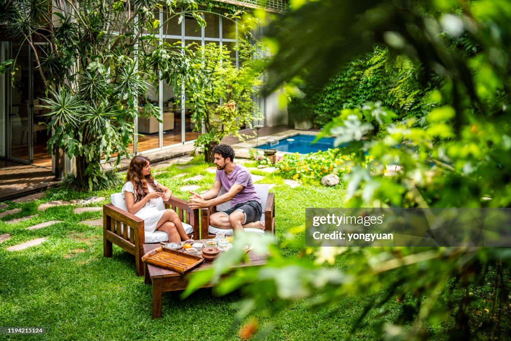 Young couple enjoying breakfast in the yard