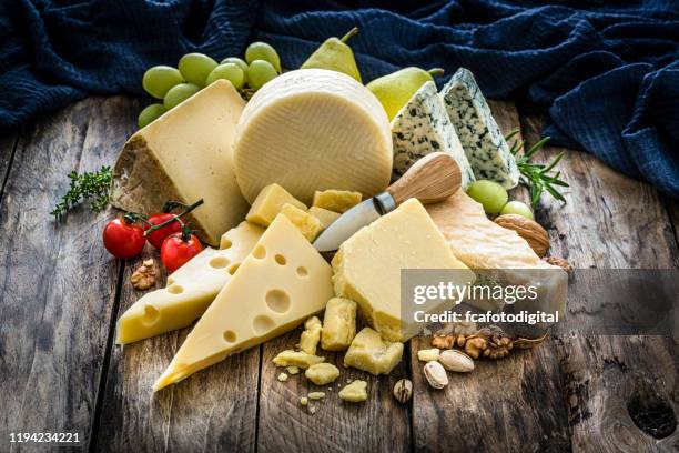 cheeses selection on rustic wooden table - cheese board stock pictures, royalty-free photos & images