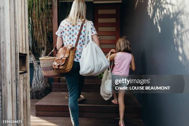 sustainable everyday life in australia - woman entering home stock pictures, royalty-free photos & images