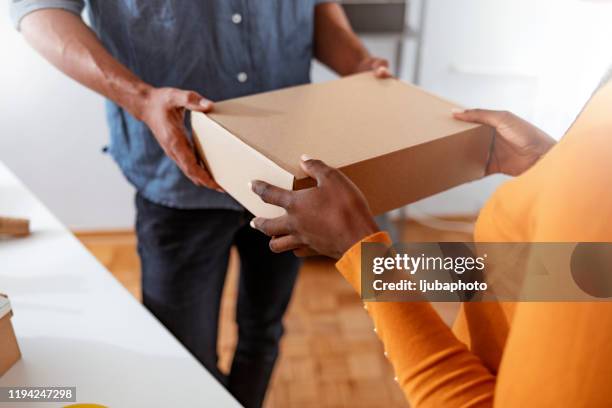 customer receiving the parcel from delivery man - send parcel stock pictures, royalty-free photos & images