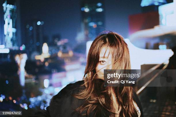 young beautiful woman with wavy hair in the city at night - unleash creativity stock pictures, royalty-free photos & images