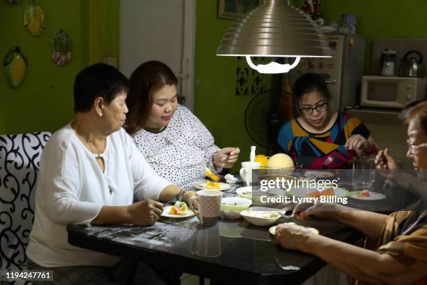 a woman has a meal with her family - filipino family dinner foto e immagini stock