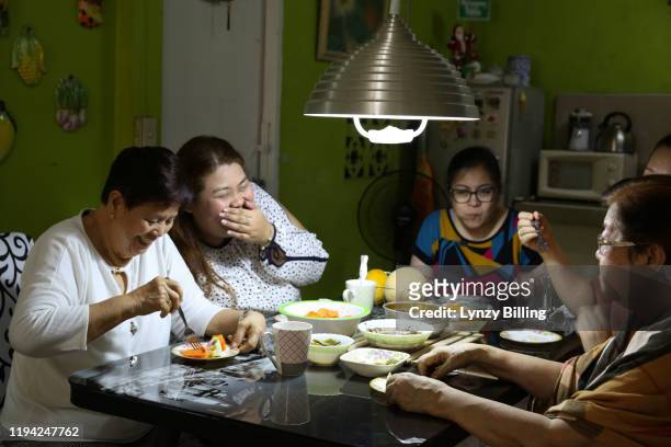 a woman has a meal with her family - filipino family dinner stock-fotos und bilder