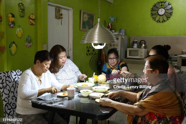 a woman has a meal with her family - filipino family dinner foto e immagini stock