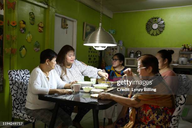 a woman has a meal with her family - filipino family dinner fotografías e imágenes de stock