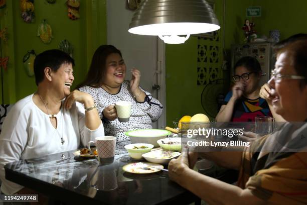 a woman has a meal with her family - filipino family dinner foto e immagini stock