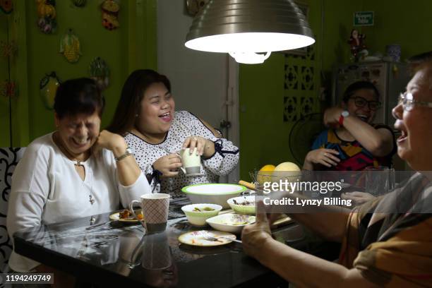 a woman has a meal with her family - philippines family stock pictures, royalty-free photos & images