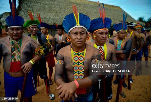 Members of the Tapirape tribe wait to perform a ceremonial dance for their leader Cacique Raoni Metuktire of the Kayapo tribe, in Piaracu village,...