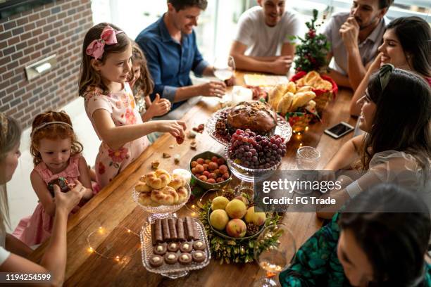 familientreffen zur weihnachtszeit am tisch - panettone stock-fotos und bilder