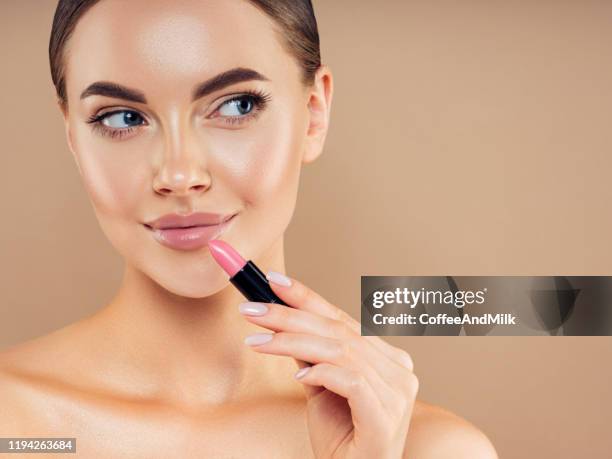 mooi meisje dat make-up toepast - lippenstift stockfoto's en -beelden