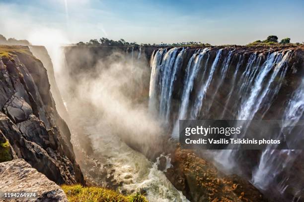 the victoria falls against the sun - zimbabwe stock pictures, royalty-free photos & images
