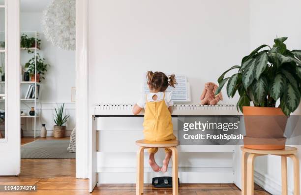 niña jugando al piano - kids instruments fotografías e imágenes de stock