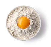 bowl of flour and egg yolk isolated on white background, top view