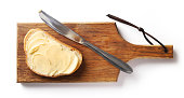 bread with butter on wooden cutting board, top view