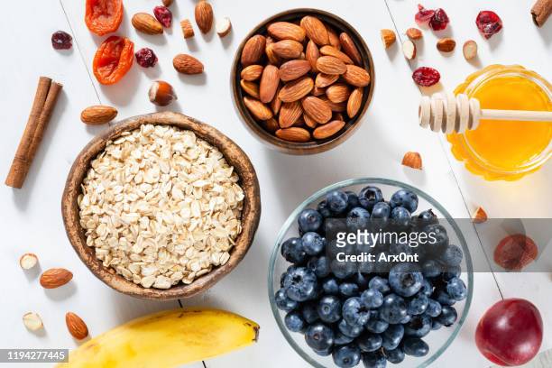 oatmeal, blueberries, almonds and honey for cooking breakfast porridge - ingredienti dolci foto e immagini stock
