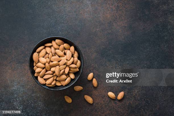 almonds in bowl on background - almond stock pictures, royalty-free photos & images