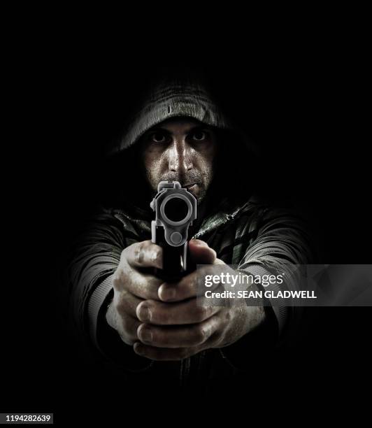 man pointing gun on black background - shooting crime photos et images de collection