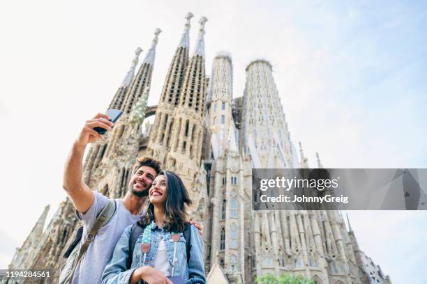 vacationers taking selfie with sagrada familia in background - sagrada família imagens e fotografias de stock