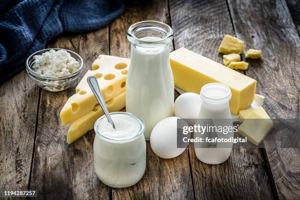 productos lácteos sobre mesa de madera rústica - dairy product fotografías e imágenes de stock