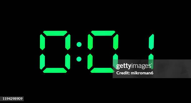 real green led digital clock showing time 0:01 - minutenwijzer stockfoto's en -beelden