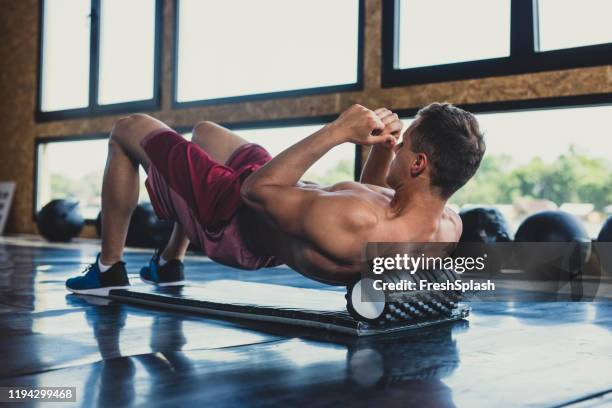 athlete using a foam roller - man massage stock pictures, royalty-free photos & images