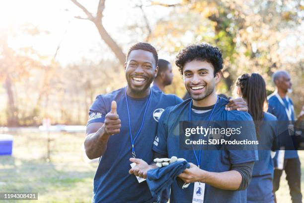 Cheerful male friends enjoy volunteering together