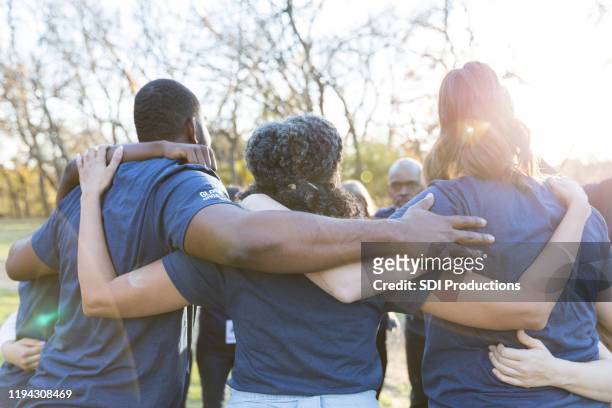 rear view of united group of volunteers - charity and relief work stock pictures, royalty-free photos & images
