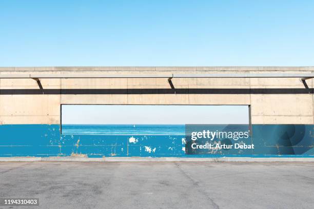 minimal urban architecture aligned with blue sea horizon. - symbiotic relationship - fotografias e filmes do acervo