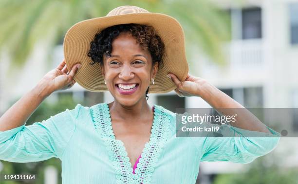 femme afro-américain mûr utilisant le chapeau de soleil - chapeau de soleil photos et images de collection