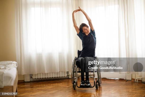 disabled young woman exercising at home - spinal cord injury stock pictures, royalty-free photos & images