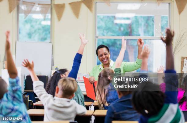 african-american teacher reading to school children - child in classroom stock pictures, royalty-free photos & images