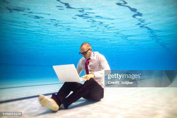 onderwater foto van zakenman dragen pak in zwembad - lowest stockfoto's en -beelden