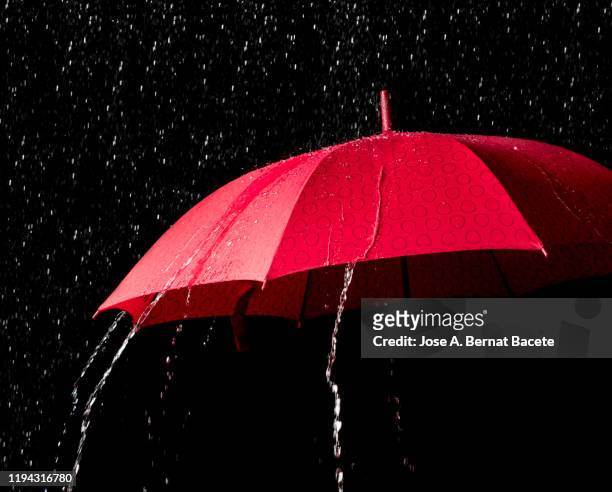 red umbrella with splash on black background. - torrential rain umbrella stock pictures, royalty-free photos & images