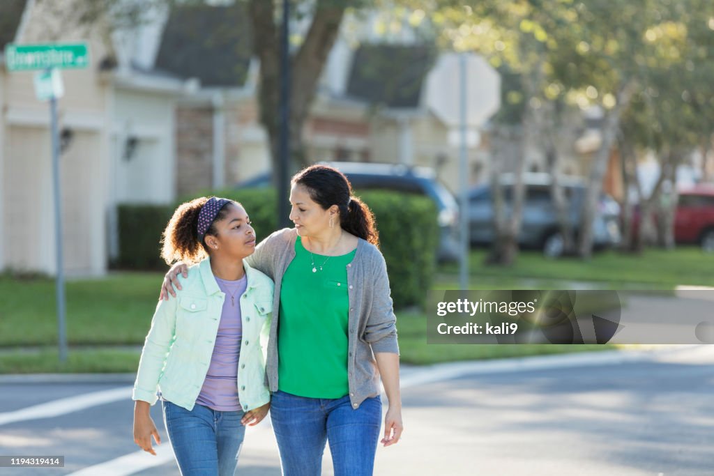 Madre e hija caminando juntas, hablando