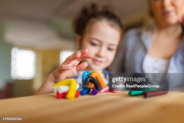 happy mother and daughter is playing with plasticine. they are using play clay to make models. - artists model stock pictures, royalty-free photos & images