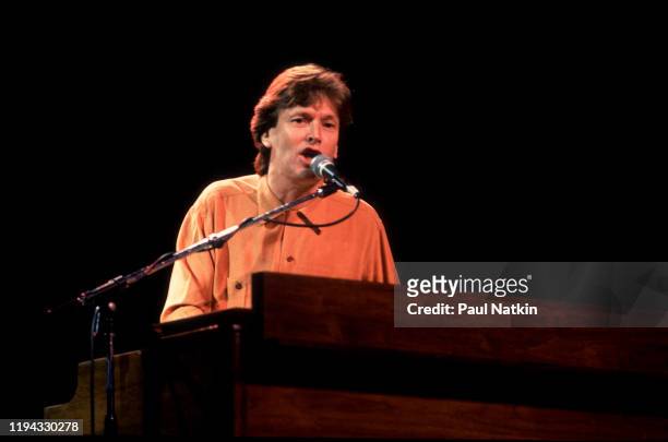 English Rock and Pop musician Steve Winwood plays keyboards as he performs onstage at the Poplar Creek Music Theater, Hoffman Estates, Illinois, July...
