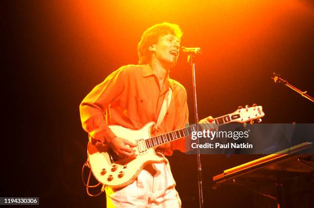 English Rock and Pop musician Steve Winwood plays guitar as he performs onstage at the Poplar Creek Music Theater, Hoffman Estates, Illinois, July 9,...