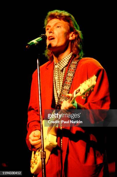 English Rock and Pop musician Steve Winwood plays guitar as he performs onstage at the Poplar Creek Music Theater, Hoffman Estates, Illinois, August...