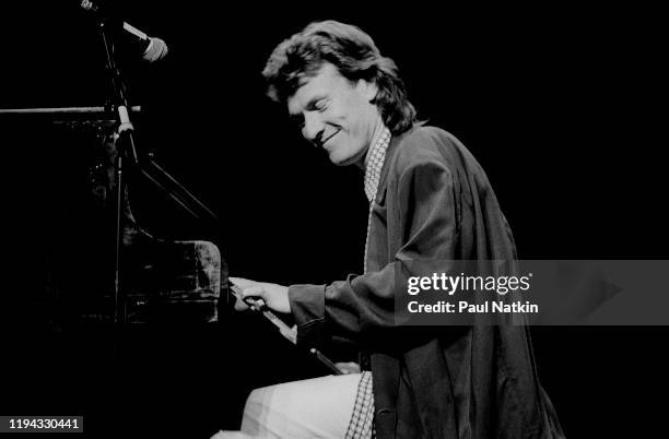 English Rock and Pop musician Steve Winwood plays keyboards as he performs onstage at the Poplar Creek Music Theater, Hoffman Estates, Illinois,...