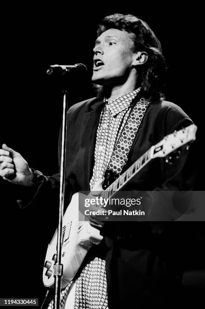 English Rock and Pop musician Steve Winwood plays guitar as he performs onstage at the Poplar Creek Music Theater, Hoffman Estates, Illinois, August...