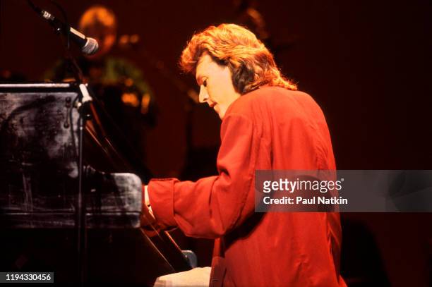 English Rock and Pop musician Steve Winwood plays keyboards as he performs onstage at the Poplar Creek Music Theater, Hoffman Estates, Illinois,...