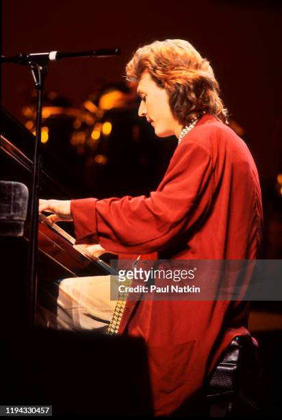 English Rock and Pop musician Steve Winwood plays keyboards as he performs onstage at the Poplar Creek Music Theater, Hoffman Estates, Illinois,...