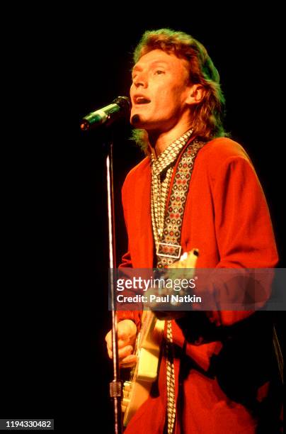 English Rock and Pop musician Steve Winwood plays guitar as he performs onstage at the Poplar Creek Music Theater, Hoffman Estates, Illinois, August...