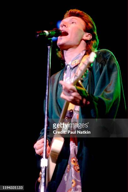 English Rock and Pop musician Steve Winwood plays guitar as he performs onstage at the UIC Pavilion, Chicago, Illinois, November 7, 1986.