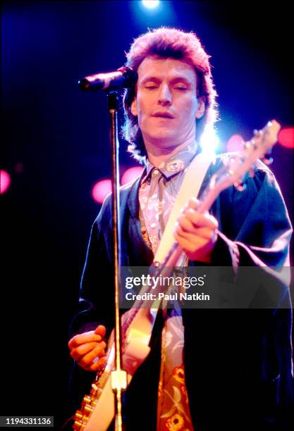 English Rock and Pop musician Steve Winwood plays guitar as he performs onstage at the UIC Pavilion, Chicago, Illinois, November 7, 1986.