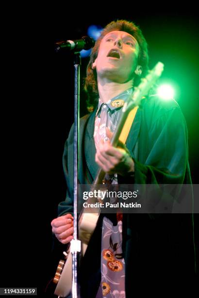 English Rock and Pop musician Steve Winwood plays guitar as he performs onstage at the UIC Pavilion, Chicago, Illinois, November 7, 1986.