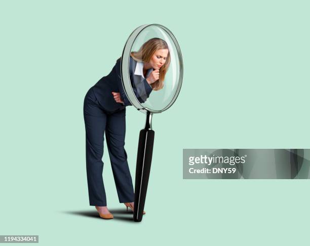 businesswoman looking through large magnifying glass - magnifying glass stock pictures, royalty-free photos & images